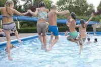 Kinderen vermaken zich in buitenzwembad 