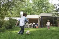 Kinderen voetballen bij de cottage