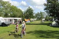 Kinderen fietsen over de camping