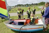 Kinderen krijgen les in windsurfen