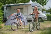 Kinderen fietsen over de camping
