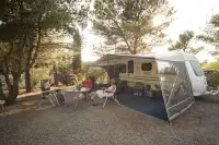 Mensen zitten buiten op de camping bij hun caravan