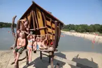 Kinderen spelen op het speeltoestel bij het recreatiemeer