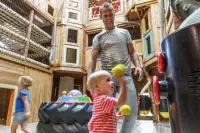 Vader en kinderen in de indoor speeltuin