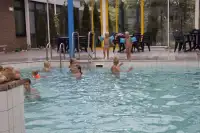 Kinderen zwemmen in het overdekte zwembad