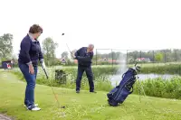 Mensen golfen op de 18-holes golfbaan direct naast het park