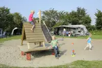 Kinderen spelen in de speeltuin